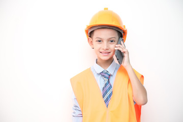 Young boy engineer isolated in white. Handsome early teenage boy portrait with engineering cloth. Talking on mobile phone.