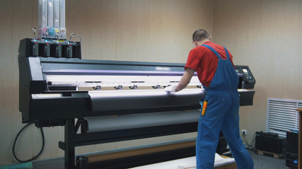 Male worker in typography working on the printing maschine
