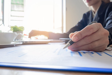 Business woman analyzing investment charts at morning time.