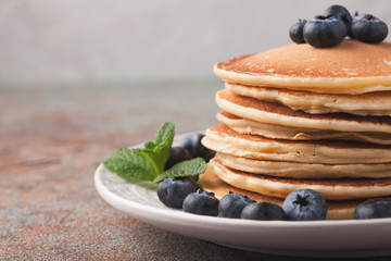 Delicious pancakes close up, with fresh blueberries, strawberries on a light background