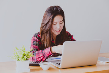 Happy businesswoman working typing in a laptop in a office with copy space