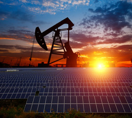 Clean power energy concept,Oil pump with solar panels and the sunset