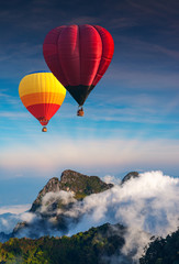 Obraz premium Aerial view colorful hot air balloons flying over with the mist at Doi Luang Chiang Dao with morning mist in Chiang Mai, Thailand..