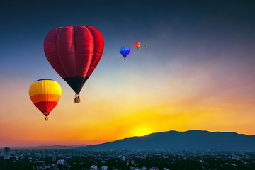 Aerial view colorful hot air balloons flying over Chiang Mai city in sunset ,Thailand..