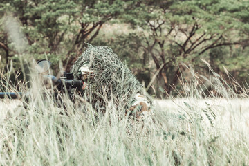 Sniper in urban combat training. Full ghillie camo suit and a high power sniper rifle. In urban...