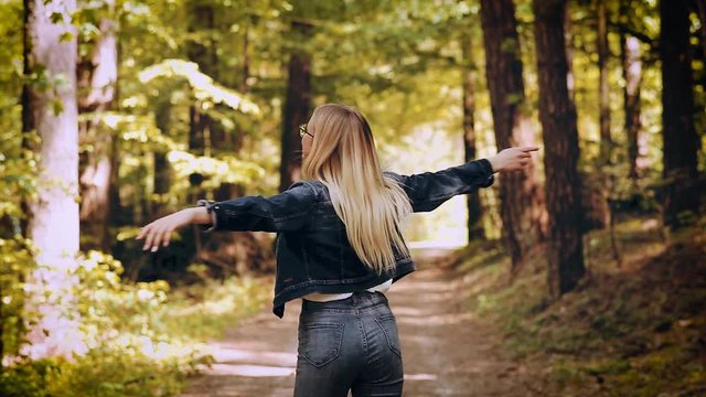 Young Blond Woman Enjoying The Nature, Outstretched Arms While Enjoying The Fresh Air In Green Forest