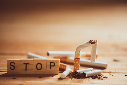 World No Tobacco Day, May 31. Close up Broken cigarette with STOP text on Wooden Block on wooden table background.