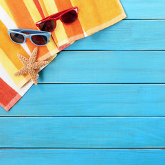 Beach background border scene with blue wood deck decking boardwalk starfish star fish sunglasses couple sunbathing square format photo