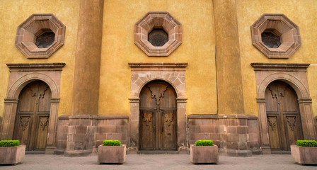 Mexican colonial style house in Queretaro Mexico, classic wood doors and decorative windows.