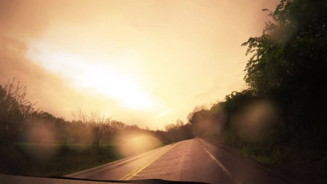 Cinematic timelapse of driving through beautiful color graded sunset road