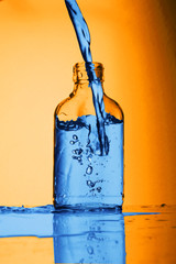 napełnianie szklanej butelki wodą