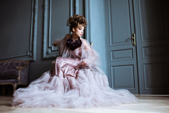 Fashionable female portrait of cute lady in pink dress indoors