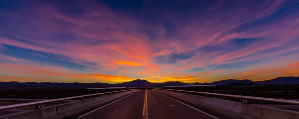 Fotobehang MARCH 12, 2017, LAS VEGAS, NV - Highway overpass above Interstate 15, south of Las Vegas, Nevada at sunset with yellowline © spiritofamerica