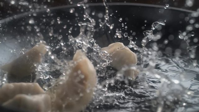 Cooking dumpling on heated pan. Shot with high speed camera, phantom flex 4K. Slow Motion.