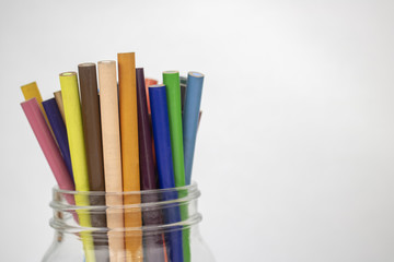 A jar of colored pencils on an isolated white background with room for text 