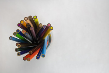 A jar of colored pencils on an isolated white background with room for text viewed from above