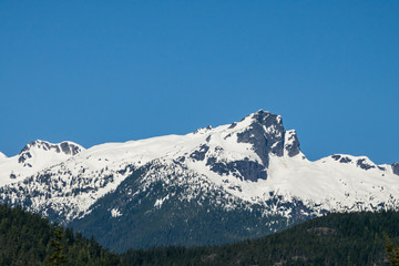 Fototapeta na wymiar mountain range covered by snow in early spring under the blue sky