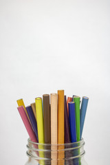 A jar of colored pencils on an isolated white background with room for text 