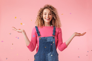 Portrait of a smiling young curly blonde girl in dress playing