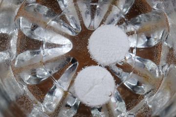 two tablets in a glass of water dissolve