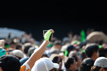 Young man taking photo of events using mobile phone