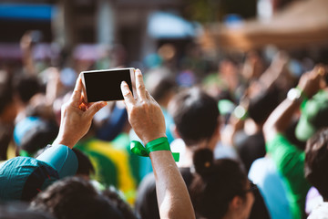 Young man taking photo of events using mobile phone