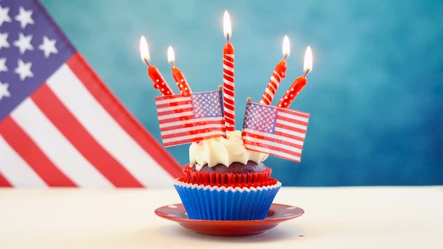 Red white and blue theme cupcakes with USA flags for Independance Day or USA theme party food.