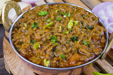 Indian Cuisine Sev Tamatar Also Called Sev Tamaeta or Sev Tameta is Served With Chapati, Papad, Onion or Raita. It is Made With Tomato And Onion Gravy With a Twist of Spicy Sev on Wooden Table
