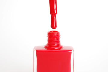 Fototapeta premium Nail Red Polish Flowing from the Bottle on White Background Beauty Fashion