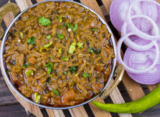 Indian Cuisine Sev Tamatar Also Called Sev Tamaeta or Sev Tameta is Served With Chapati, Papad, Onion or Raita. It is Made With Tomato And Onion Gravy With a Twist of Spicy Sev on Wooden Table