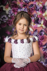 Girl in a purple dress on a floral background