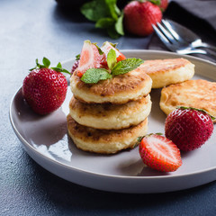 Cottage cheese pancakes withstrawberry on blue concrete table background. Breakfast or Lunch Concept. Copy space