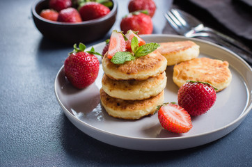 Cottage cheese pancakes withstrawberry on blue concrete table background. Breakfast or Lunch Concept