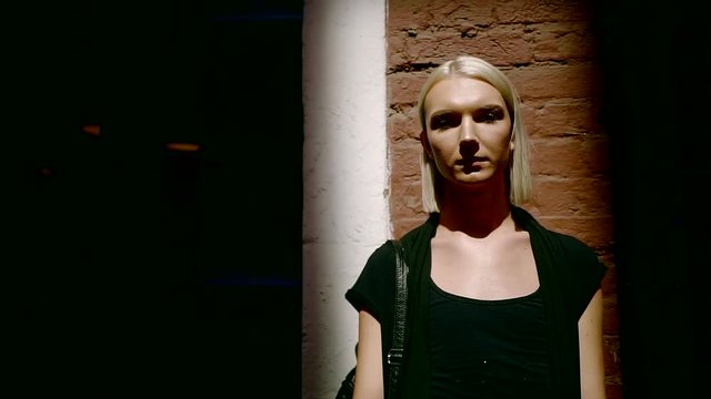 portrait of a young transsexual who stands near the wall, an informal teenager strolling around the city