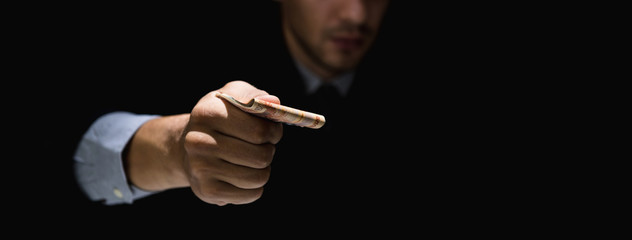 Businessman secretly giving away money in the dark