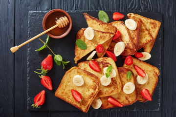 French toasts with fruits on slate tray