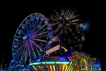 July 18, 2017 VENTURA CALIFORNIA - Illuminated ferris wheel with neon lights and fireworks at the Ventura County Fair, Ventura, California - Powered by Adobe