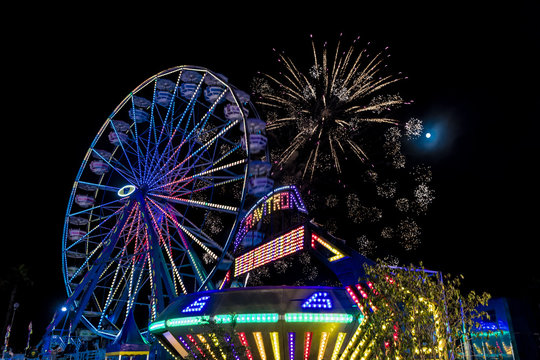 July 18, 2017 VENTURA CALIFORNIA - Illuminated ferris wheel with neon lights and fireworks at the Ventura County Fair, Ventura, California