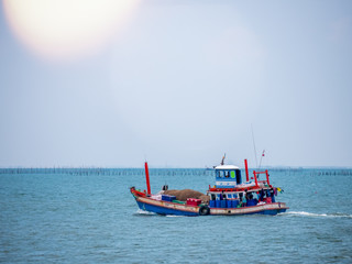 Fototapeta premium Thai fishing boat traditional used as a vehicle for finding fish in the sea at sunset.