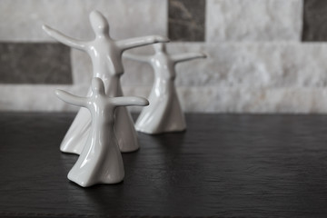 isolated porcelain figurines of mevlana on black background . ramadan concept. symbol of love and tolerance