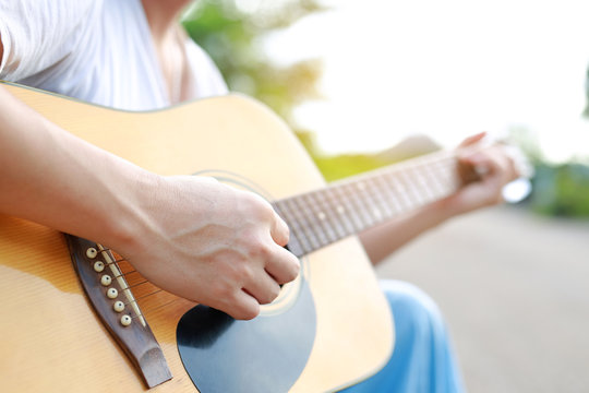 Male playing acoustic guitar in the nature.