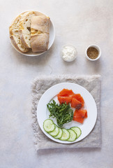 Salmon, cucumber and cream cheese rye sandwich on the wooden background, top view. Delicious snack or appetizer for wine.