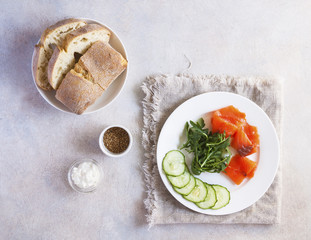 Salmon, cucumber and cream cheese rye sandwich on the wooden background, top view. Delicious snack or appetizer for wine.