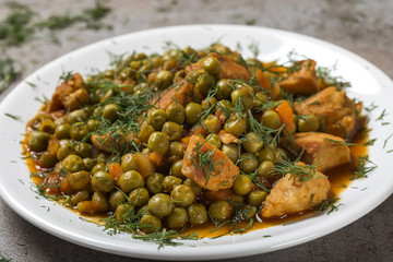 Chiken stew with peas, carrot and tomato sauce on plate