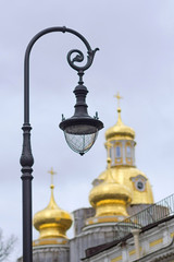 Old street lamp on the background of the golden domes of the chu