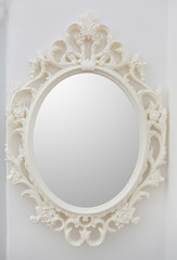 Ornate mirror on the wall. Round frame.
