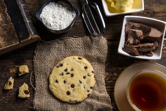 cookies , chocolate , and old book on a wooden table