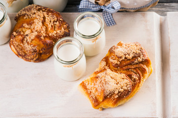 Bread buns, jars with milk on a cutting board 