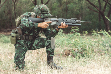 Soldier reloading his assault rifle. Chinese professional soldier reloading his weapon and putting his magzine inside his gun. Kneeing down action.