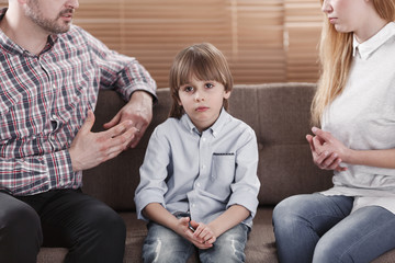 Sad child while parents arguing